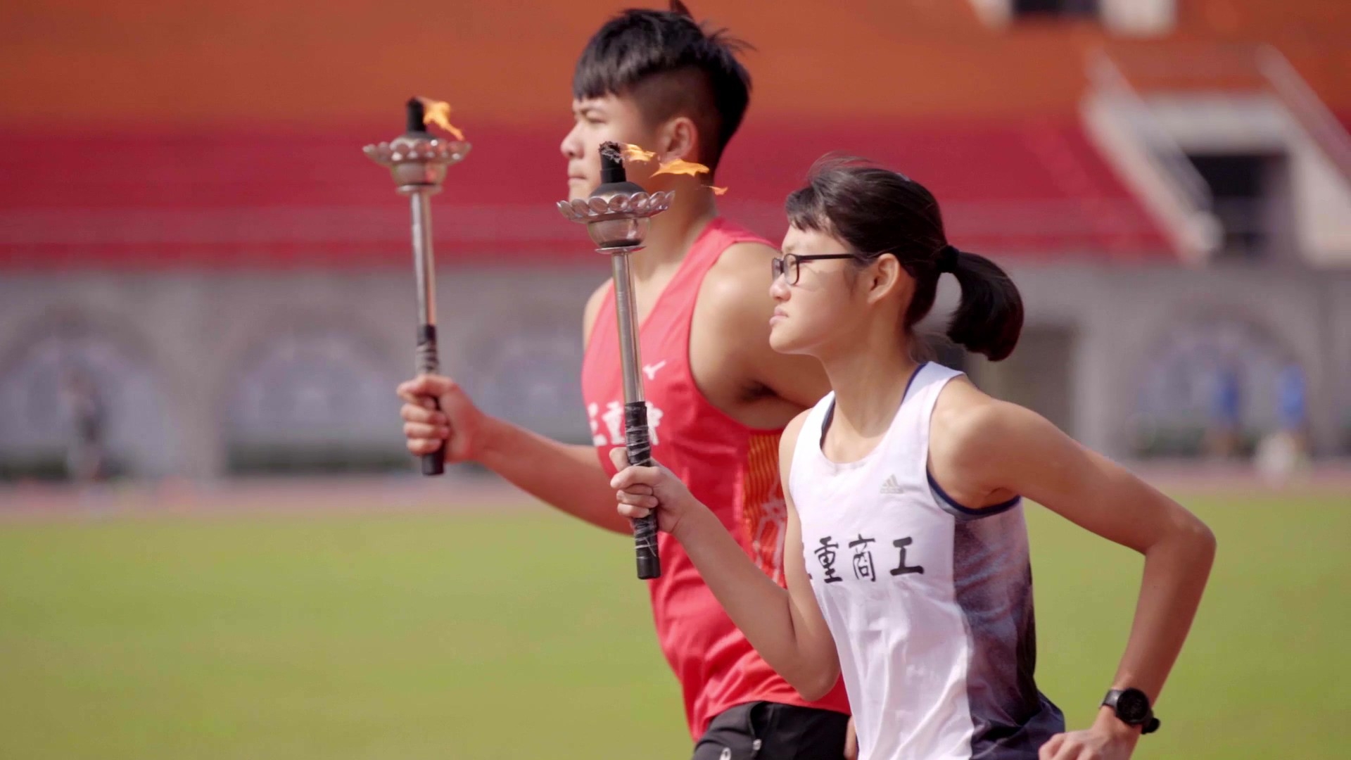 新北巿中小學運動會聖火由三重高中陳宜助(左)；三重商工吳昕芳(右)代表傳遞