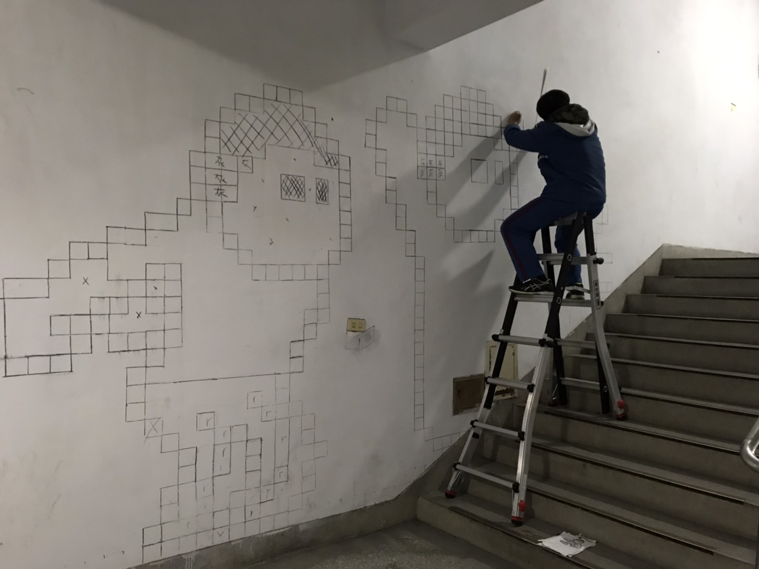 學生在牆壁上打草稿作畫的過程