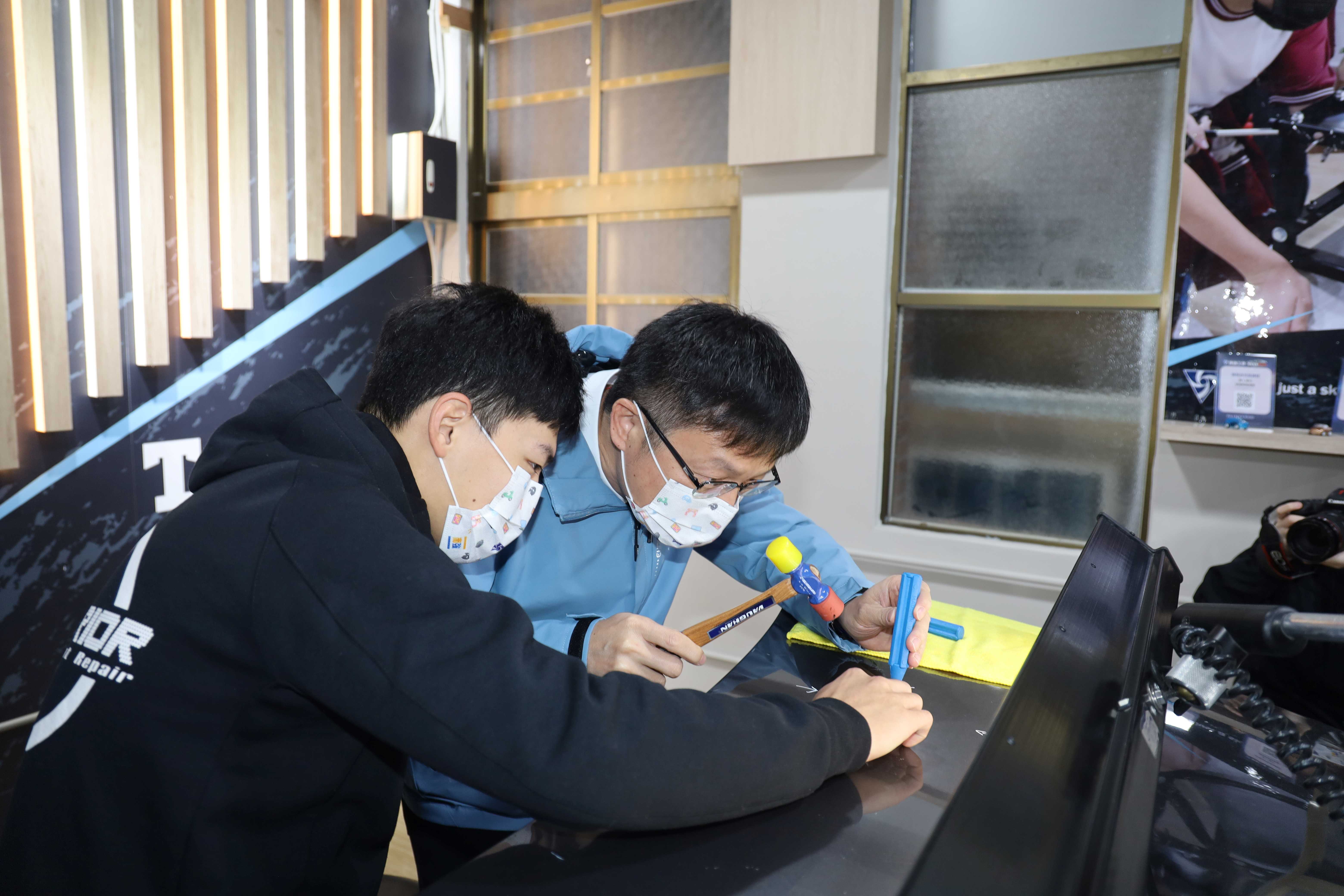 教育局長張明文(右)與南強汽修科學生體驗車門微板金修護.JPG