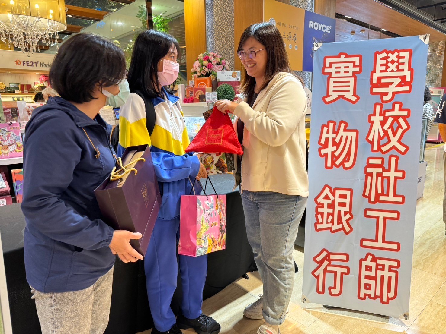 學校輔導教師(左)陪同凡凡(中)來到板橋大遠百領取端午節禮盒
