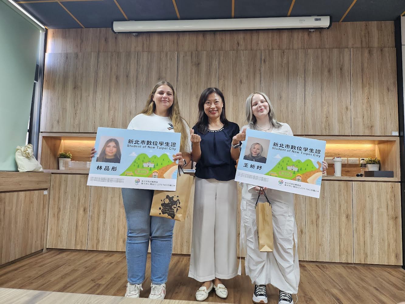Tuuli(右)及Cristina(左)持新北市數位學生證手牌與劉淑芬校長合影.jpg