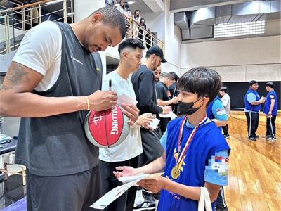 學生開心帶著籃球請球員們簽名互動