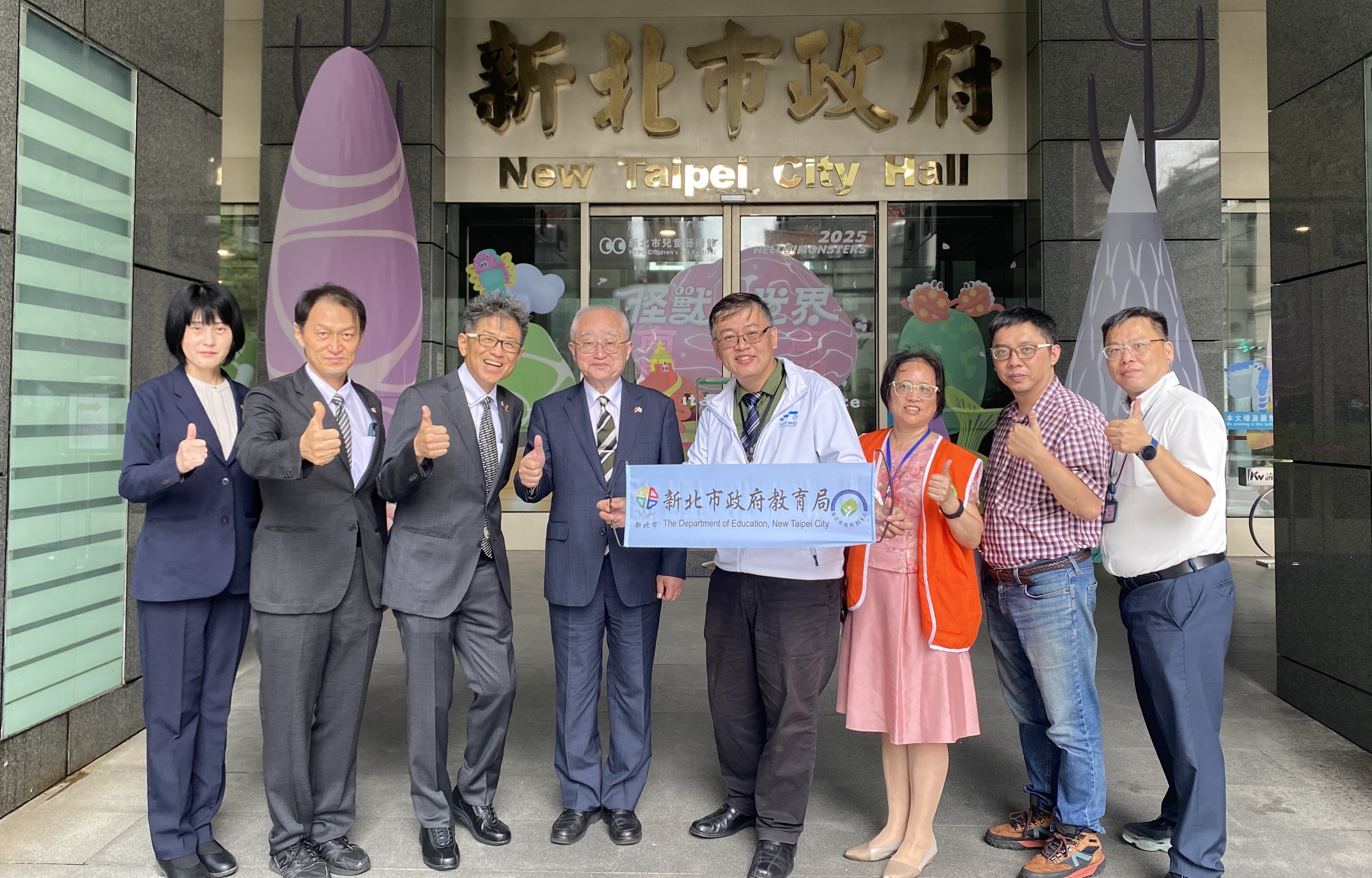 魚津市教育左一委員會山瀬敬教育長(左四)、魚津市產業建設部商工觀光課課長高森哲也(左二)、魚津市教育委員會教育總務課折川直子主查(左一)、富山縣立大學清水義彥副教授(左三)，由新北市教育局新民科代理科長盧柏安(右四)代表歡迎