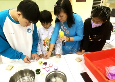 具有越南新住民身份的貢寮國小楊小梅校長(右二)帶著現場孩子們動手做越南椰奶果凍與鳳