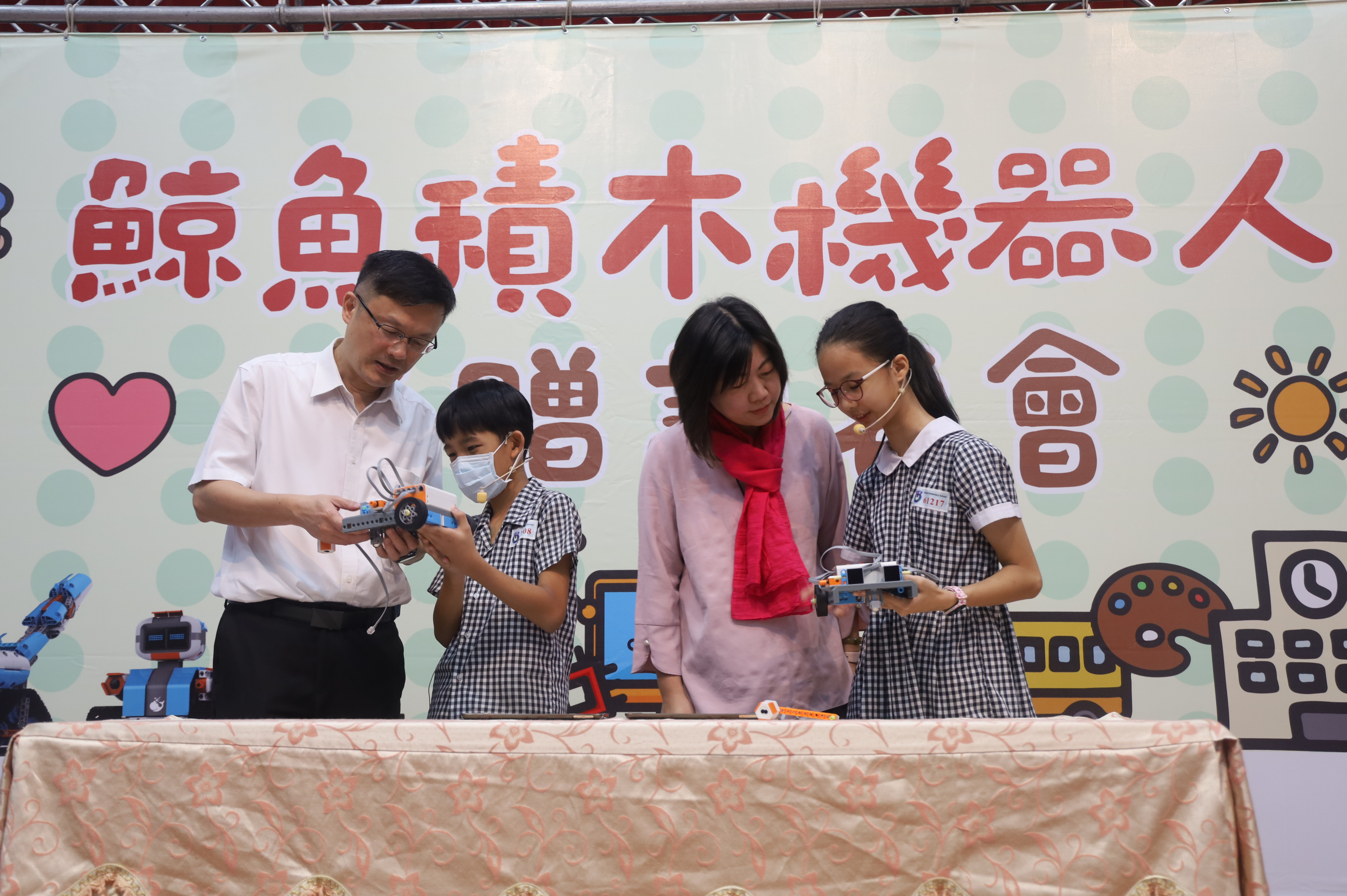 4.教育局長(左一)與陳儀君議員(右二)和學生一起進行鯨魚機器人互動遊戲