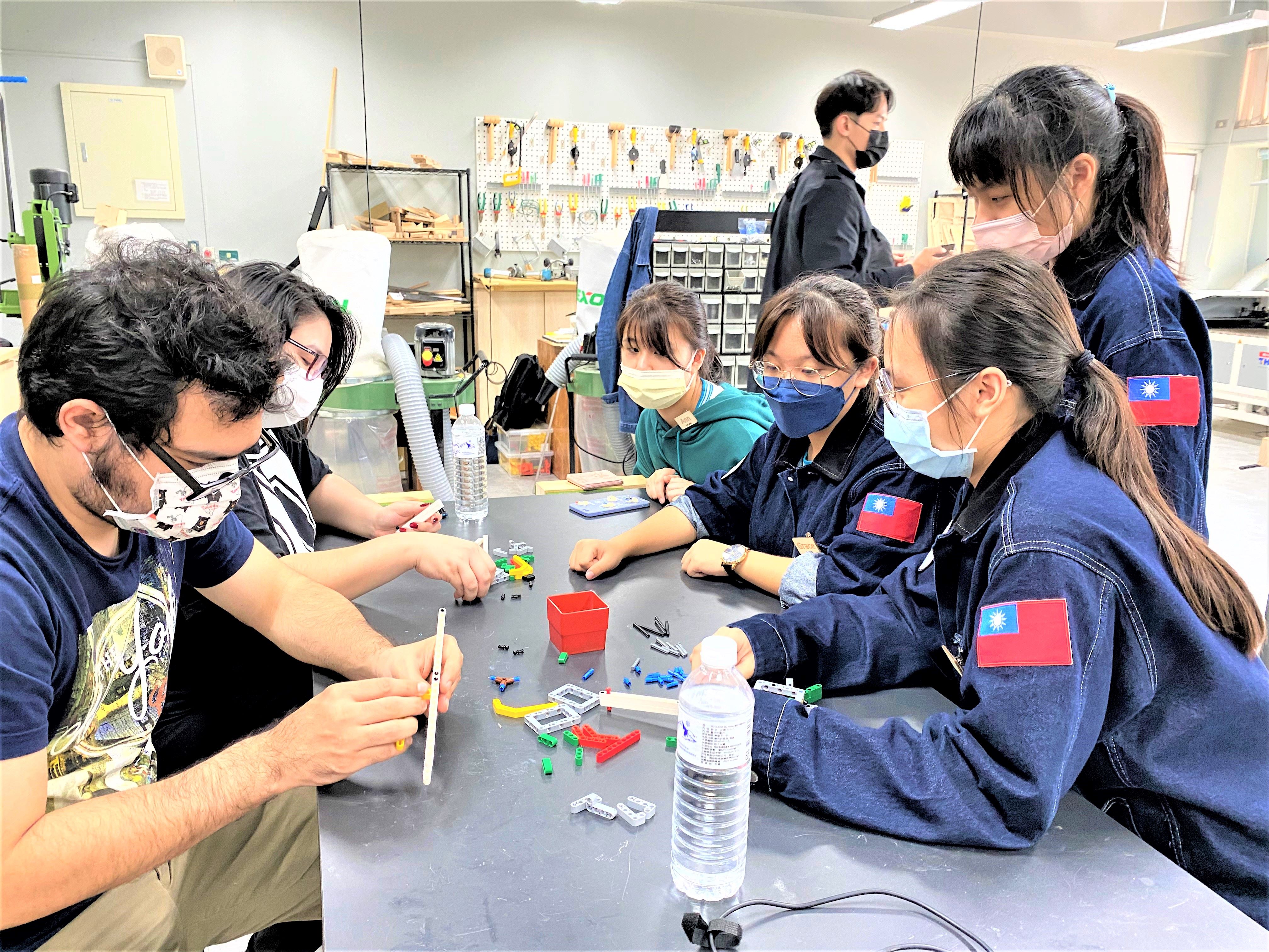 石碇高中學生細心跟外籍生講解如何打造自己的一把樂高手槍.jpg