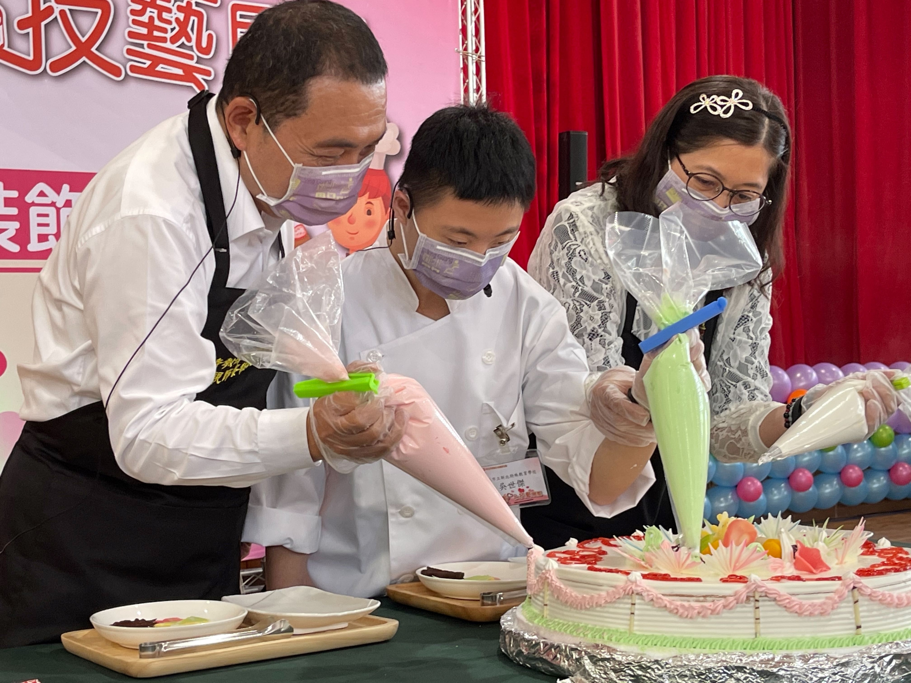 1.市長與新北特殊教育學校高三吳世傑同學及媽媽共同裝飾母親節蛋糕.