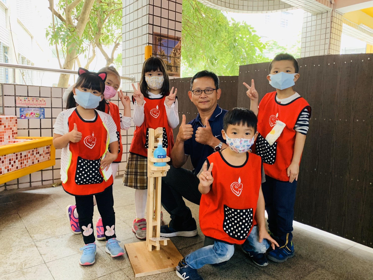 3中正國中林東保主任與幼兒園與腳踏式按壓洗手乳裝置合影
